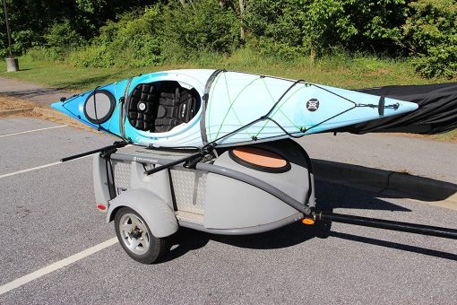 Kayak on racks on top of a trailer, Cable lock is around the bow and stern of the kayak and threaded through the racks making secure from theft