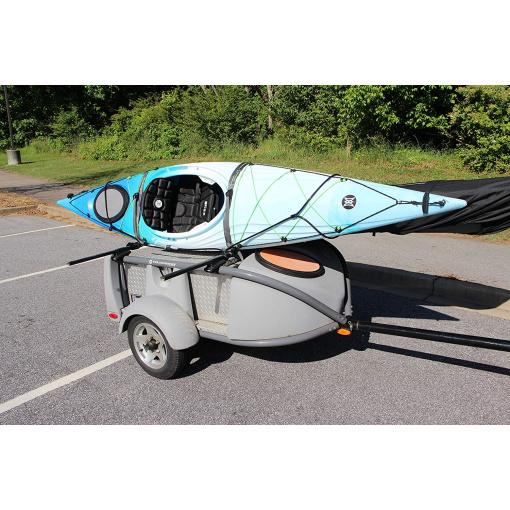 Kayak on racks on top of a trailer, Cable lock is around the bow and stern of the kayak and threaded through the racks making secure from theft